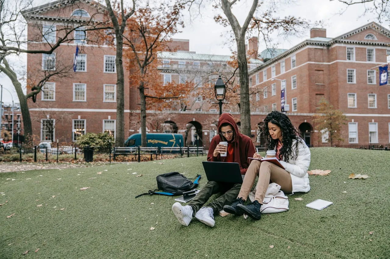 International students studying together on a university campus lawn