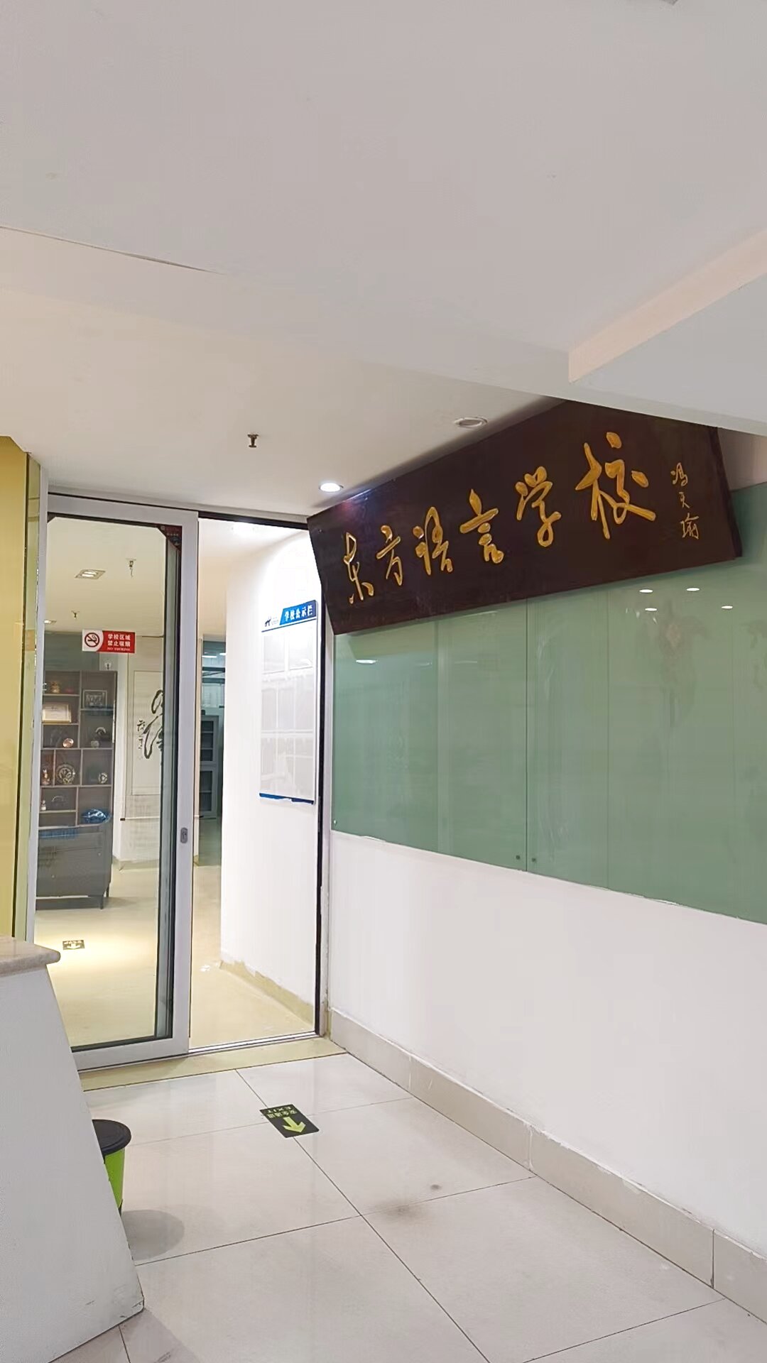 KCEL school entrance with carved wooden sign reading 东方语言学校
