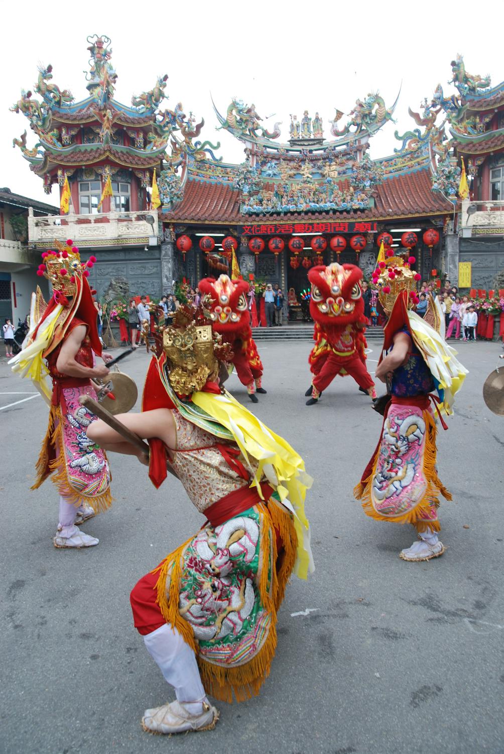 Traditional Chinese lion dance performers in elaborate costumes at a Chinese temple festival