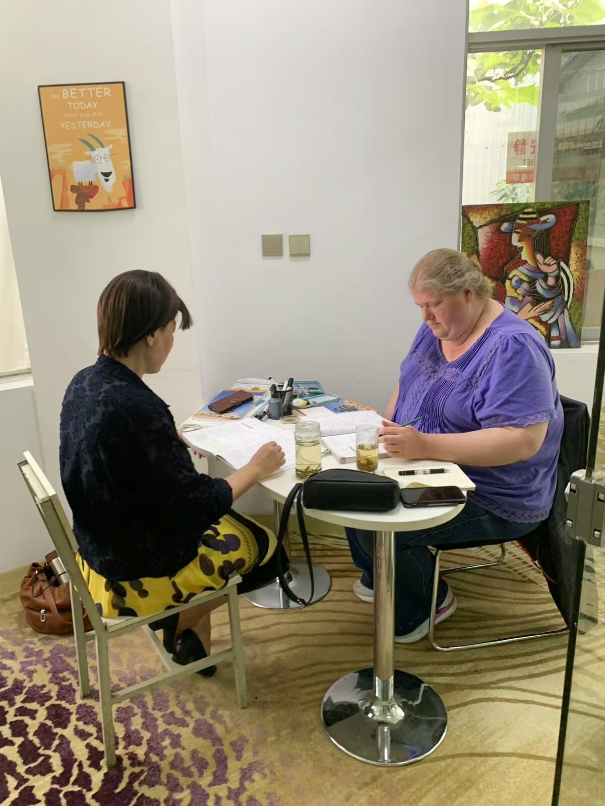 KCEL teacher guiding a student through Chinese study materials in a private classroom