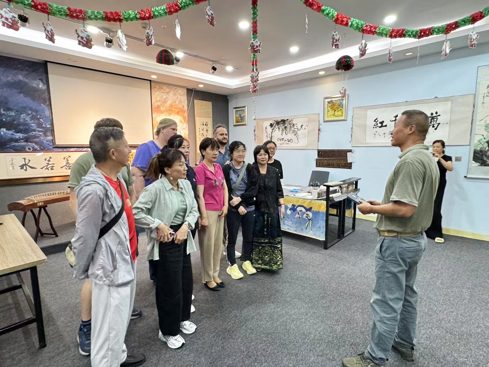 Students visiting the KCEL culture hall with Chinese calligraphy, paintings, and guzheng instruments